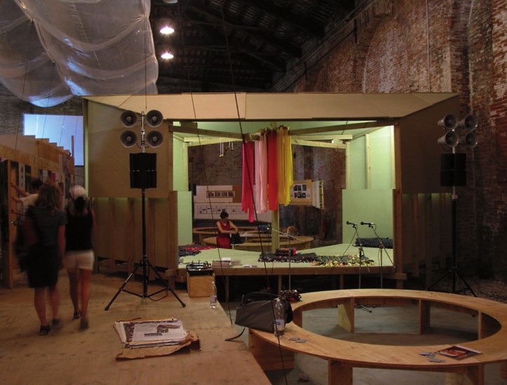 Interior de la Utopia Station. La estructura de madera, con los bancos circulares y el escenario, ha sido diseñada por los artistas Liam Gillick y Rirkrit Tiravanija. © Archivo de la Bienal de Venecia.